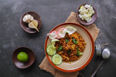 mie tek tek or fried noodle made with egg noodles with chicken, cabbage, mustard greens, meatballs, scrambled eggs. indonesian food