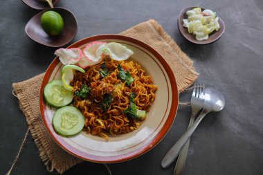 mie tek tek or fried noodle made with egg noodles with chicken, cabbage, mustard greens, meatballs, scrambled eggs. indonesian food