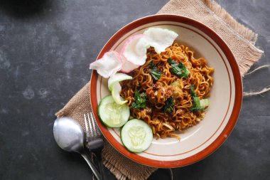 mie tek tek or fried noodle made with egg noodles with chicken, cabbage, mustard greens, meatballs, scrambled eggs. indonesian food
