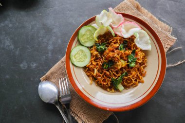 mie tek tek or fried noodle made with egg noodles with chicken, cabbage, mustard greens, meatballs, scrambled eggs. indonesian food