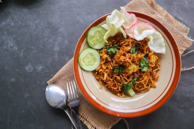 mie tek tek or fried noodle made with egg noodles with chicken, cabbage, mustard greens, meatballs, scrambled eggs. indonesian food