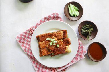 Martabak Telor or Murtabak Telur or mutabbaq. Savory pan-fried pastry stuffed with egg, meat and spices. Martabak Telur is one of Indonesia street food.