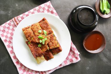 Martabak Telor or Murtabak Telur or mutabbaq. Savory pan-fried pastry stuffed with egg, meat and spices. Martabak Telur is one of Indonesia street food.
