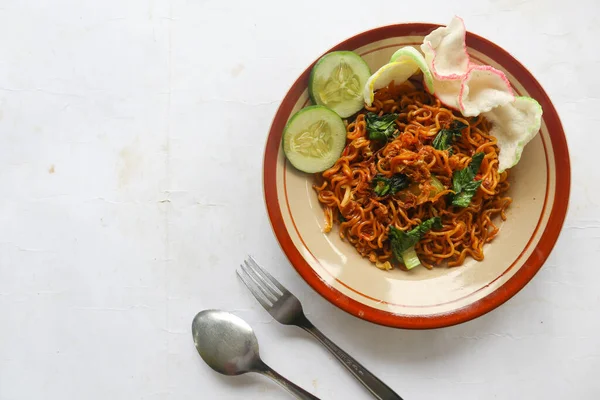 mie tek tek or fried noodle made with egg noodles with chicken, cabbage, mustard greens, meatballs, scrambled eggs. indonesian food