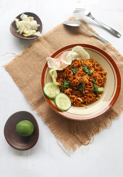 mie tek tek or fried noodle made with egg noodles with chicken, cabbage, mustard greens, meatballs, scrambled eggs. indonesian food