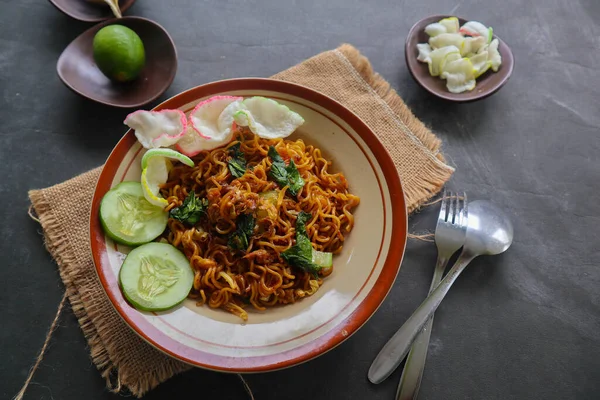 mie tek tek or fried noodle made with egg noodles with chicken, cabbage, mustard greens, meatballs, scrambled eggs. indonesian food