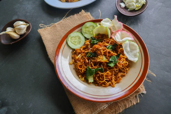 mie tek tek or fried noodle made with egg noodles with chicken, cabbage, mustard greens, meatballs, scrambled eggs. indonesian food