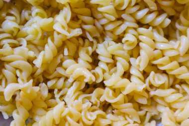 Fusilli spagetti, arka plan görüntüsü olarak Fusilli makarna. Görüntü dokusu sarmal makarna. Üst Manzara. Kopyala, metin için boşluk