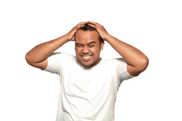 stock image A photo of a Asian man stressed two hands holding stress head wearing a white T-shirt isolated by white background. looks depressed