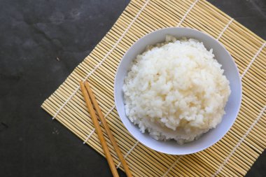Beyaz buğulanmış pirinç ya da Nasi putih beyaz arka planda izole edilmiş küçük bir kasede servis edilir.