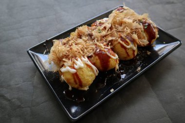 Takoyaki, buğday unundan, ahtapot etinden veya diğer dolgulardan yapılan, sos, mayonez ve katsuobushi veya ahşap balığı talaşı şeklinde servis edilen bir Japon yemeğidir..