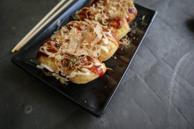 Takoyaki, buğday unundan, ahtapot etinden veya diğer dolgulardan yapılan, sos, mayonez ve katsuobushi veya ahşap balığı talaşı şeklinde servis edilen bir Japon yemeğidir..