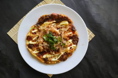 Okonomiyaki, geleneksel Japon pizzası, Okonomiyaki 'den Japon fırında pizza. Un, su veya dashi ile sulandırılmış, artı lahana, tavuk yumurtası, deniz ürünleri ve bir teppan 'da kızartılmış.