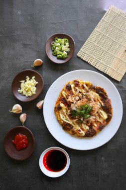 Okonomiyaki, geleneksel Japon pizzası, Okonomiyaki 'den Japon fırında pizza. Un, su veya dashi ile sulandırılmış, artı lahana, tavuk yumurtası, deniz ürünleri ve bir teppan 'da kızartılmış.