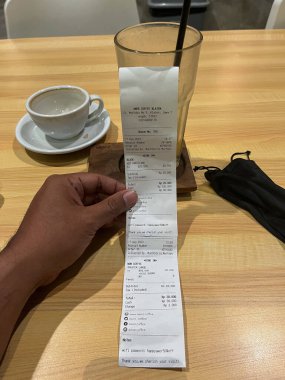 Makbuz. Bir fatura ile erkek eli yakın çekim, bir sürü çek makbuzu, hizmetler için artan gümrük tarifesi
