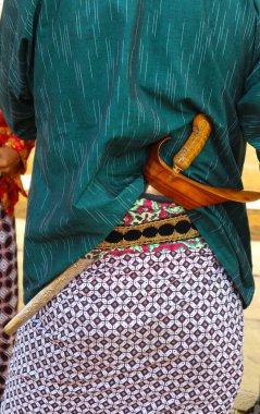 keris. Geleneksel Java kıyafetleri giymiş ve sırtında keris taşıyan bir adam..