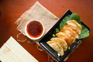 Kızarmış wonton. Acı biberli wonton. Masada hardallı, yeşil soğanlı karides ya da et köftesi çorbası.