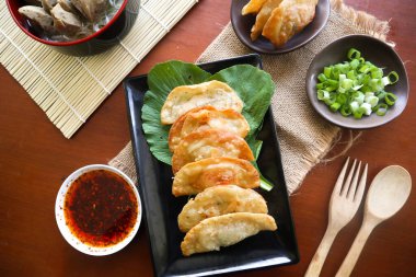 Kızarmış wonton. Acı biberli wonton. Masada hardallı, yeşil soğanlı karides ya da et köftesi çorbası.