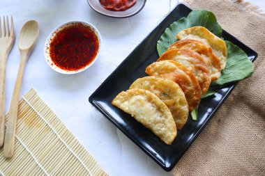 Kızarmış wonton. Acı biberli wonton. Hardallı karides ya da et köftesi çorbası, yeşil soğan, beyaz arka planda.