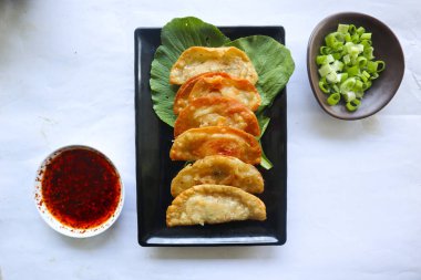 Kızarmış wonton. Acı biberli wonton. Hardallı karides ya da et köftesi çorbası, yeşil soğan, beyaz arka planda.