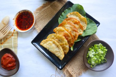 Kızarmış wonton. Acı biberli wonton. Hardallı karides ya da et köftesi çorbası, yeşil soğan, beyaz arka planda.