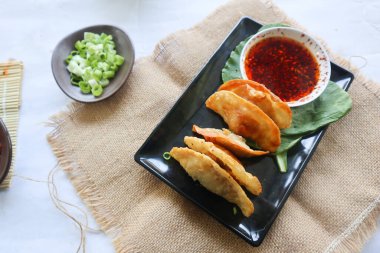 Kızarmış wonton. Acı biberli wonton. Hardallı karides ya da et köftesi çorbası, yeşil soğan, beyaz arka planda.