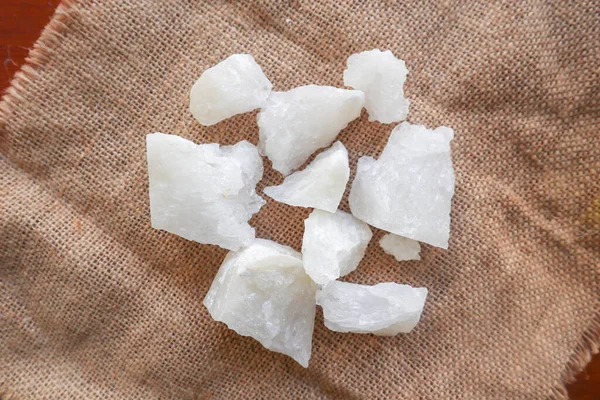 alum, Crystal clear alum stones or Potassium alum on plate, decorated with flowers. Useful for beauty and spa treatment. Use to treat body odor under the armpits as deodorant and make water clear.
