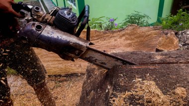 Oduncunun biri elektrikli testere kullanarak odun kesiyor..