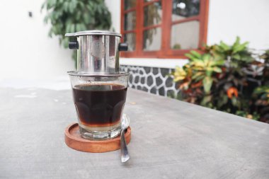 Vietnam damlası, cam bardaklarda yoğunlaştırılmış süt ve geleneksel metal kahve makinesi phin ile Vietnam kahvesi. Geleneksel Vietnam kahvesi yapma yöntemi. Açık havada servis edilir.