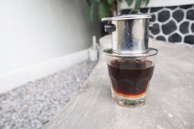 Vietnam damlası, cam bardaklarda yoğunlaştırılmış süt ve geleneksel metal kahve makinesi phin ile Vietnam kahvesi. Geleneksel Vietnam kahvesi yapma yöntemi. Açık havada servis edilir.