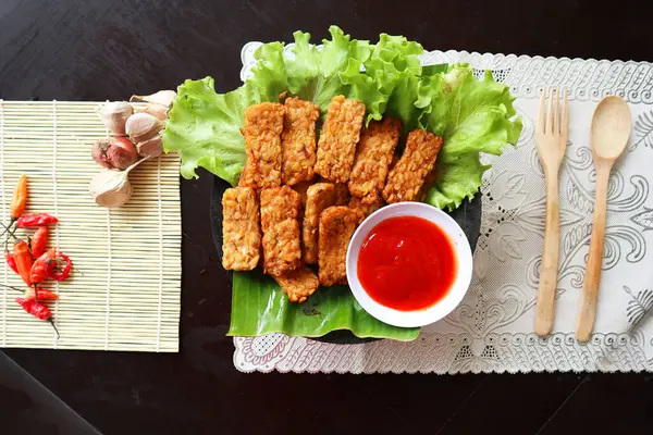 stock image Tempeh, Tempe Goreng or Fried tempeh is Indonesia traditional food, made from fermented soybean seeds. with sambal (chilli sauce), served on table, mendoan