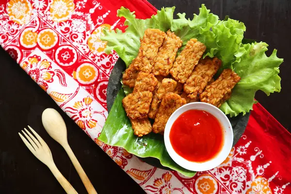 stock image Tempeh, Tempe Goreng or Fried tempeh is Indonesia traditional food, made from fermented soybean seeds. with sambal (chilli sauce), served on table, mendoan