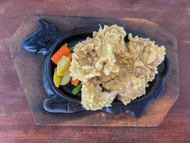 Patatesli tavuk bifteği, havuç, ahşap masada sıcak tabakla servis edilen yeşil fasulye.