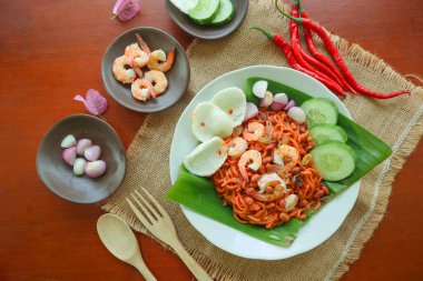 Mi Aceh, Mie Aceh or Acehnese noodles is a spicy dish typical of Aceh consisting of thick yellow noodles, slices of beef, mutton or shrimp, sliced red onions, cucumbers with a savory and spicy curry sauce. clipart