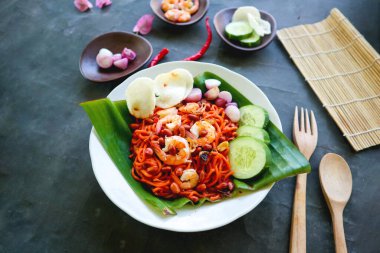 Mi Aceh, Mie Aceh or Acehnese noodles is a spicy dish typical of Aceh consisting of thick yellow noodles, slices of beef, mutton or shrimp, sliced red onions, cucumbers with a savory and spicy curry sauce clipart