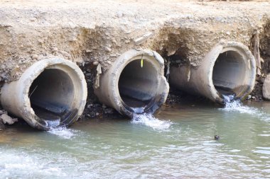 Kanalizasyon borusu. Su, bir sonraki nehre giden bir drenaj borusundan akıyor.