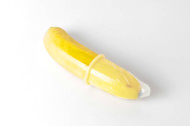 A banana is wrapped in a transparent condom on it. A metaphor of sex, sexuality, penis.