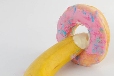 A banana is being inserted into an donat. A metaphor of sex, sexuality, penis and vagina, Sex concept