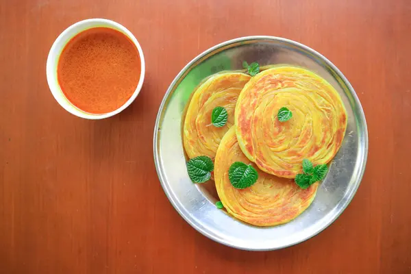 stock image Roti Canai or Paratha Bread with Curry Sauce, Chilli Flakes and Yogurt, on bacakground