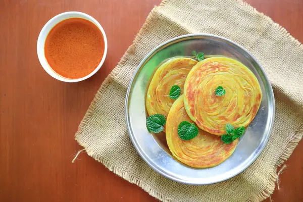 stock image Roti Canai or Paratha Bread with Curry Sauce, Chilli Flakes and Yogurt, on bacakground