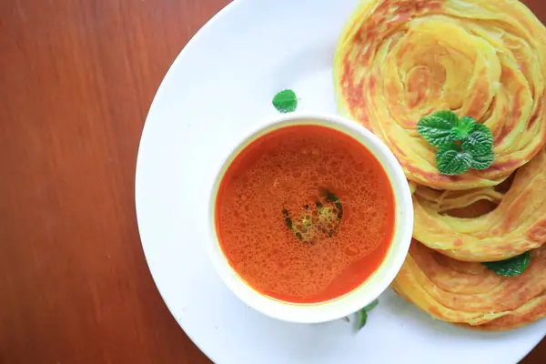 stock image Roti Canai or Paratha Bread with Curry Sauce, Chilli Flakes and Yogurt, on bacakground