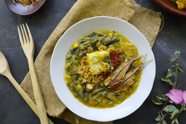 stock image Manado Porridge or Tinutuan Porridge is tradisional porridge. Manadonese rice porridge, mixed with pumpkin, corn, vegetables. Served with tofu salted fish and chili sauce or sambal