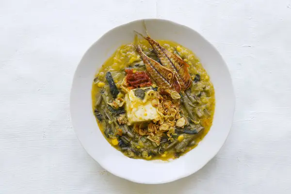 stock image Manado Porridge or Tinutuan Porridge is tradisional porridge. Manadonese rice porridge, mixed with pumpkin, corn, vegetables. Served with tofu salted fish and chili sauce or sambal