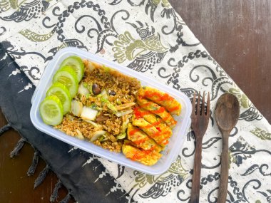 Kızarmış pirinç, omlet, salatalık dilimleri, Asyalılar için öğle yemeği.