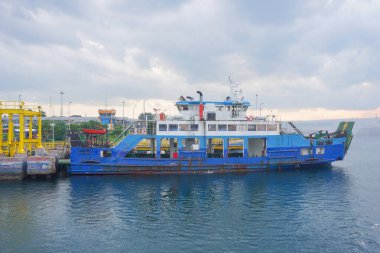 Denizi geçen feribot, kamyonlar, arabalar ve yolcular, araçlar taşıyan bir teknenin güvertesi. Bali Boğazı 'nda yoğun deniz trafiği