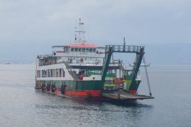 Denizi geçen feribot, kamyonlar, arabalar ve yolcular, araçlar taşıyan bir teknenin güvertesi. Bali Boğazı 'nda yoğun deniz trafiği