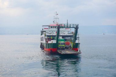 Denizi geçen feribot, kamyonlar, arabalar ve yolcular, araçlar taşıyan bir teknenin güvertesi. Bali Boğazı 'nda yoğun deniz trafiği