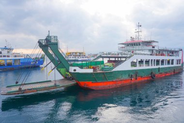 Denizi geçen feribot, kamyonlar, arabalar ve yolcular, araçlar taşıyan bir teknenin güvertesi. Bali Boğazı 'nda yoğun deniz trafiği