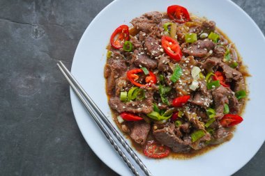 Bulgogi, soslu ve baharatlı sığır etinden yapılan bir Kore yemeğidir. siyah arkaplan