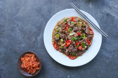 Bulgogi, soslu ve baharatlı sığır etinden yapılan bir Kore yemeğidir. siyah arkaplan
